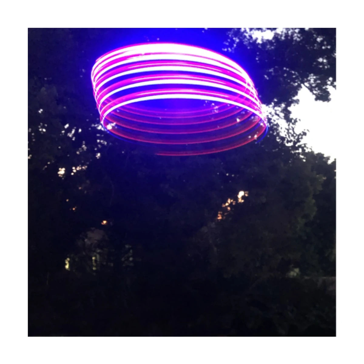 Tosy UFO U-Fly LED light-up returning flying disc in action at night outdoor play