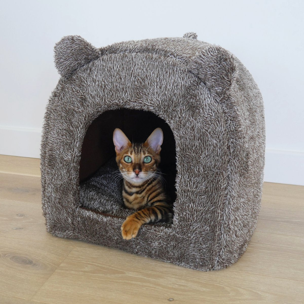 Cat resting inside the brown Rosewood Luxury Teddy Bear Cat Cave Bed in a home setting