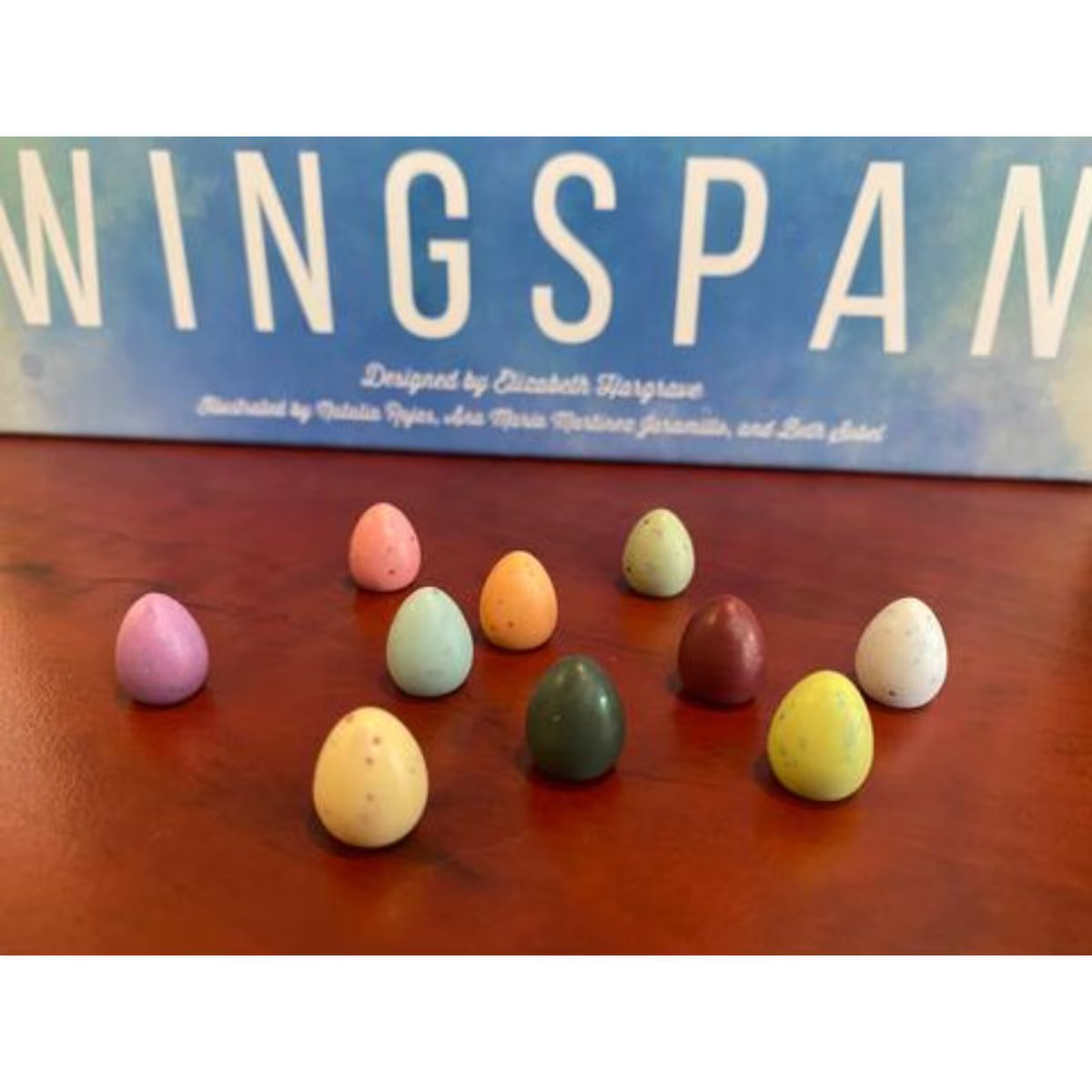 Wingspan speckled egg accessory tokens displayed in front of Wingspan game box