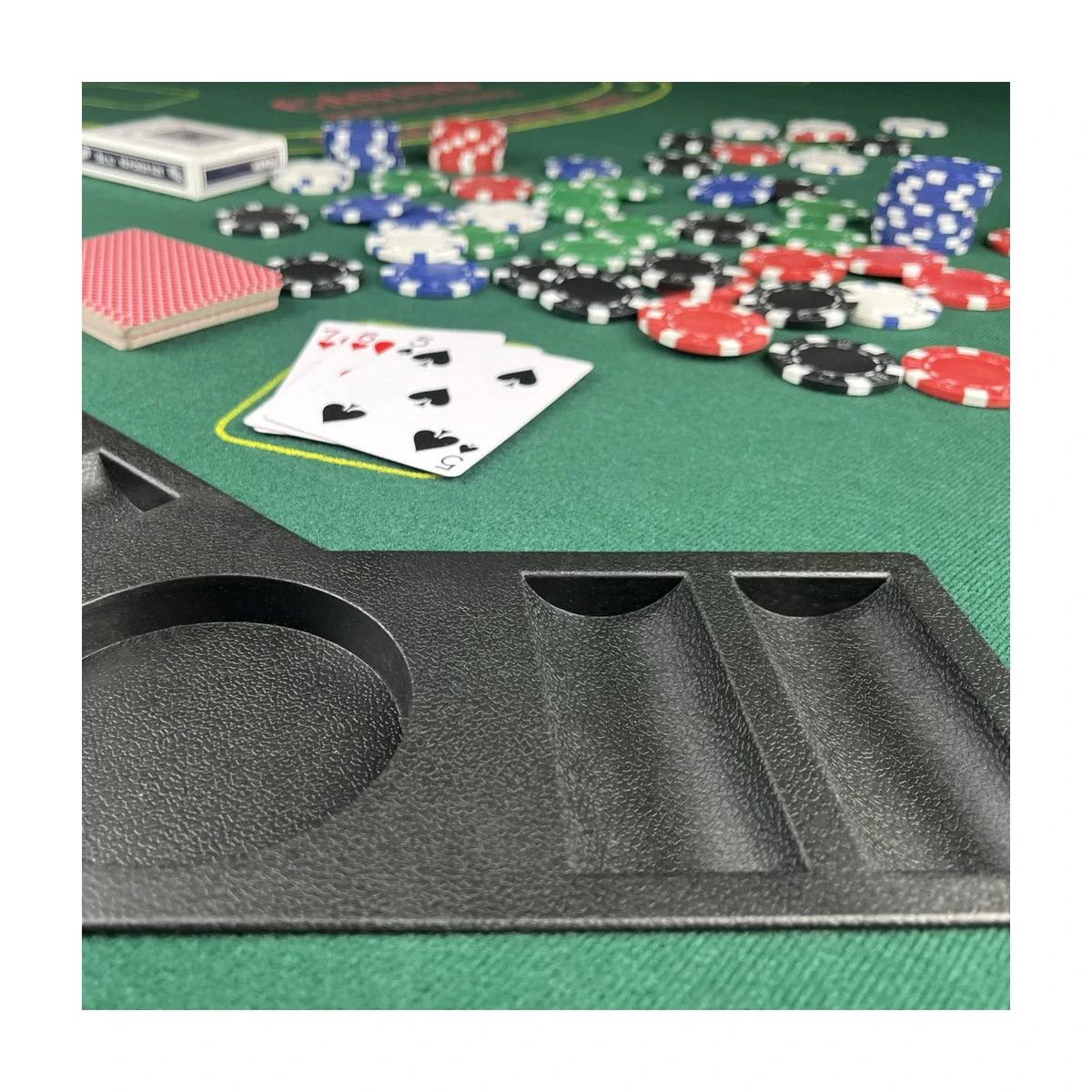 Close up of poker table cup holder and chip tray with textured edge rail on green felt