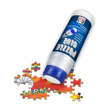 Puzzle glue applicator bottle on jigsaw puzzle pieces for preserving and bonding a finished puzzle before framing