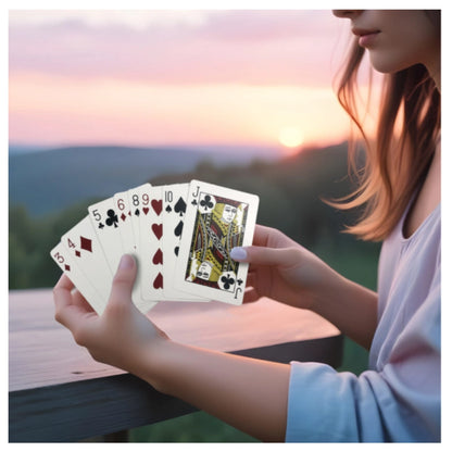 Person holding playing cards outdoors during sunset ideal for card games and magic performance