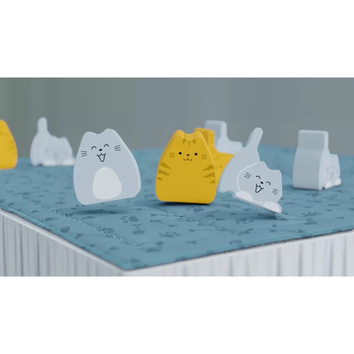 boop board game gameplay close-up showing yellow and grey cat pieces positioned on the quilted bed