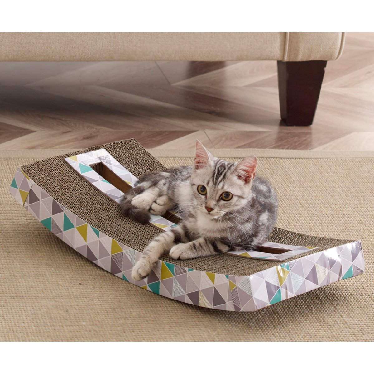 Cat resting on Catstages Scratch and Rock cardboard scratcher