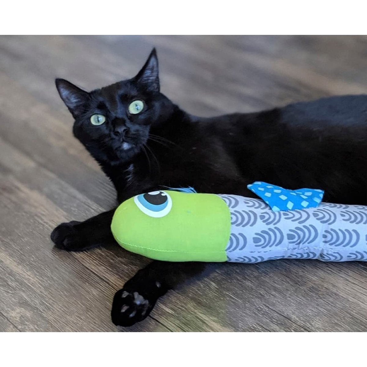 Black cat lying with the Catstages Catnip Crunch Fish cat toy