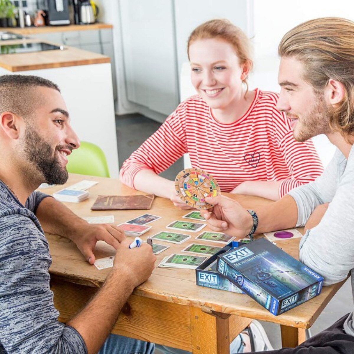 players enjoying a cooperative EXIT escape room board game at the table