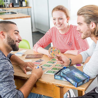 Players enjoying EXIT Dead Man on the Orient Express cooperative escape room board game at a table