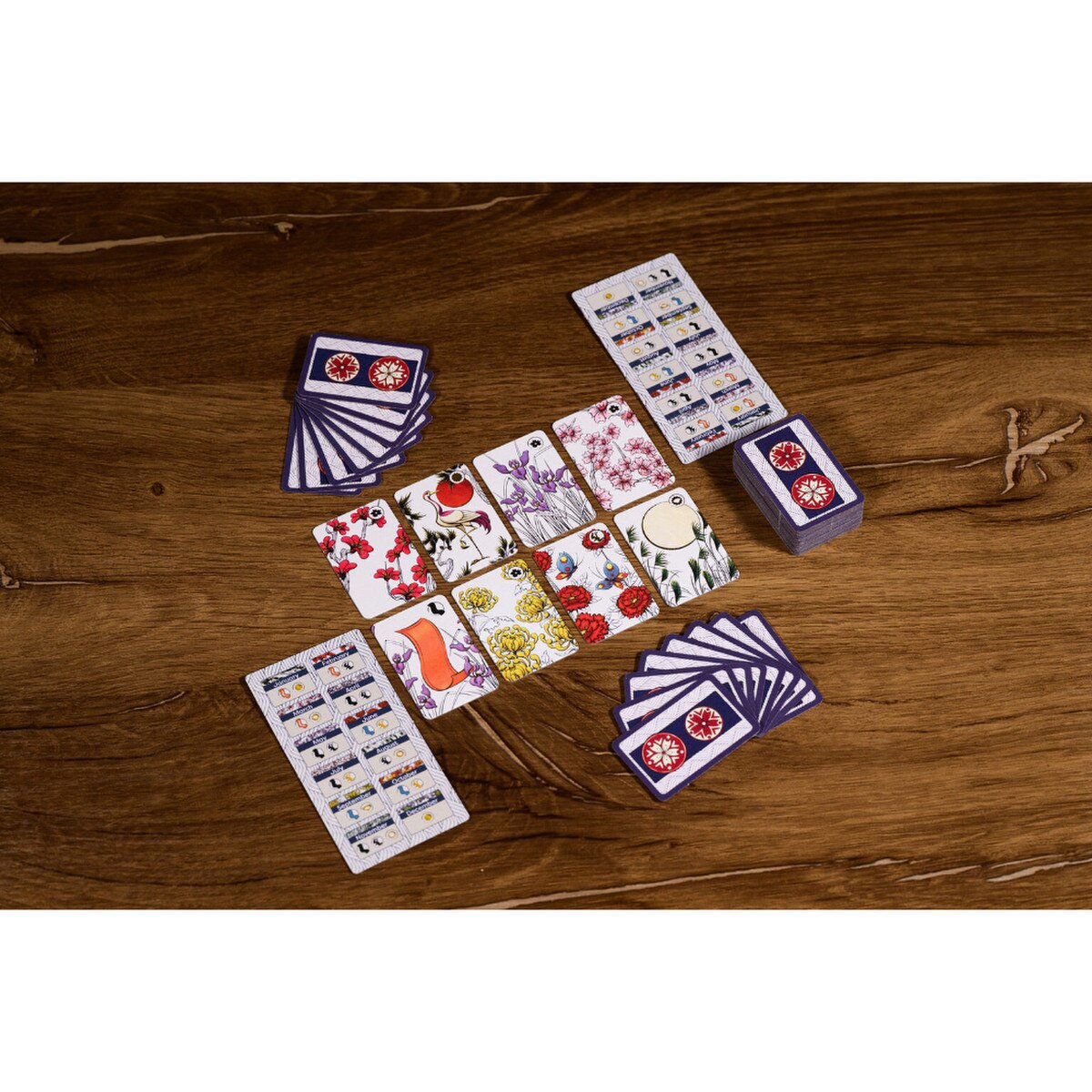 Koi-Koi Hanafuda card game gameplay layout showing matching cards and player aids on a wooden table