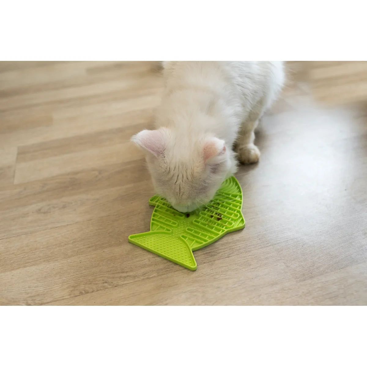 Cat using LickiMat Casper lick mat for slow feeding enrichment calm licking activity at home