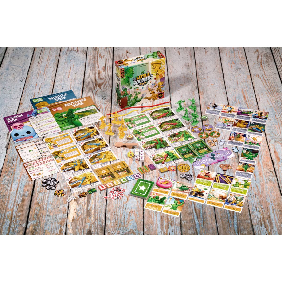 Little Soldiers miniatures game components layout with plastic figurines, cards, dice, tokens, books, cords and wooden spoon catapult