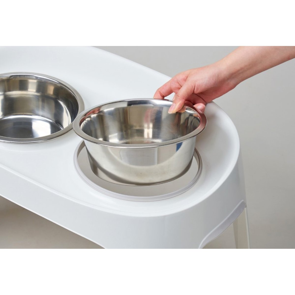 Removable stainless steel bowl being lifted from the Moderna Skybar elevated dog feeder