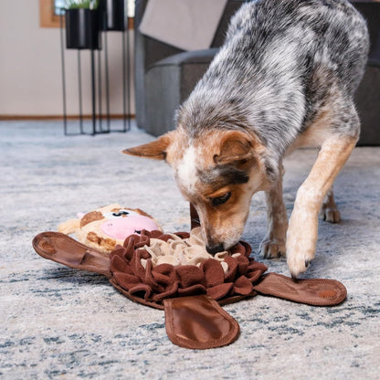 Dog sniffing and searching for treats in the Nina Ottosson Snuffle Palz Cow Large plush snuffle mat puzzle toy