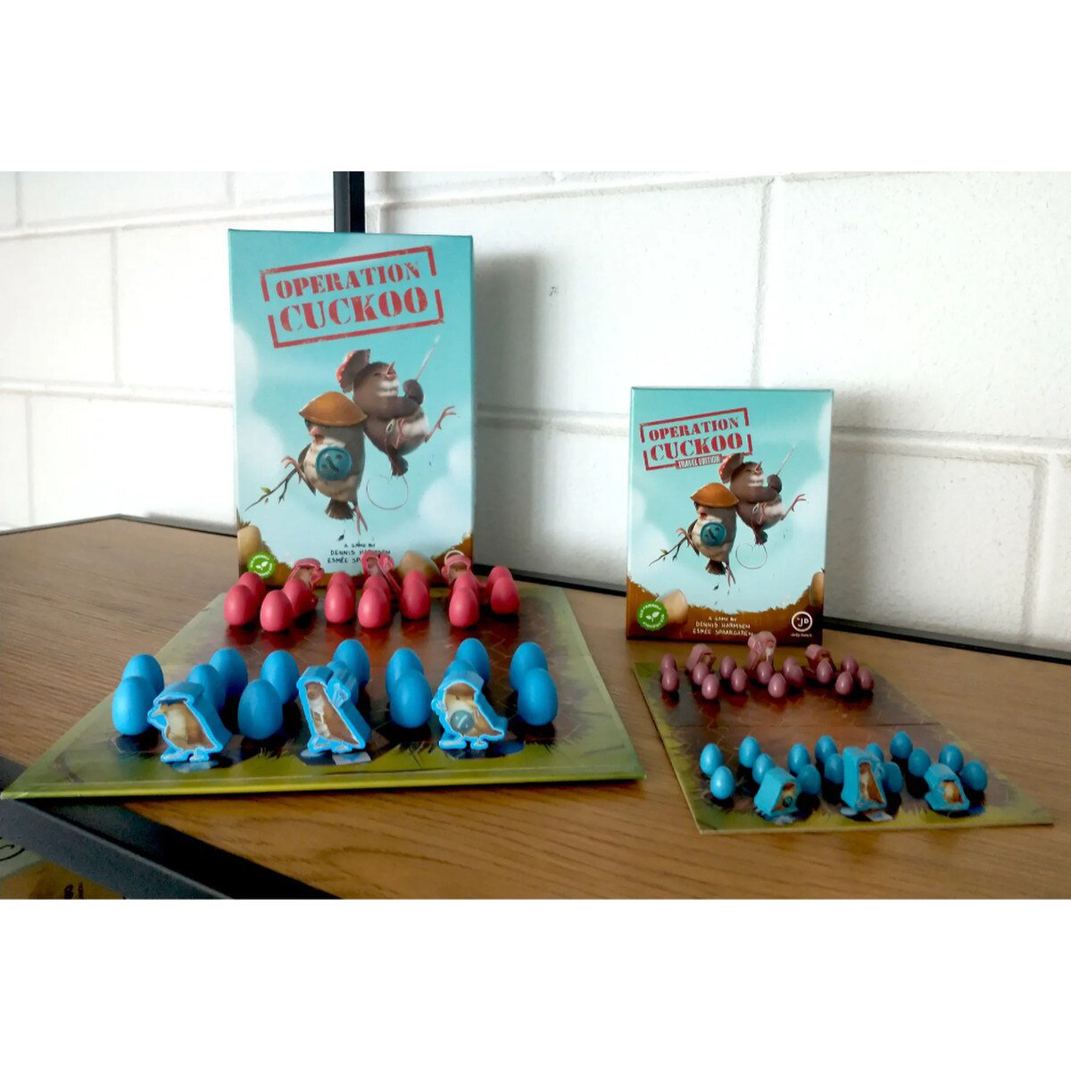 Operation Cuckoo standard and Travel Edition shown side by side with their game boards and wooden playing pieces