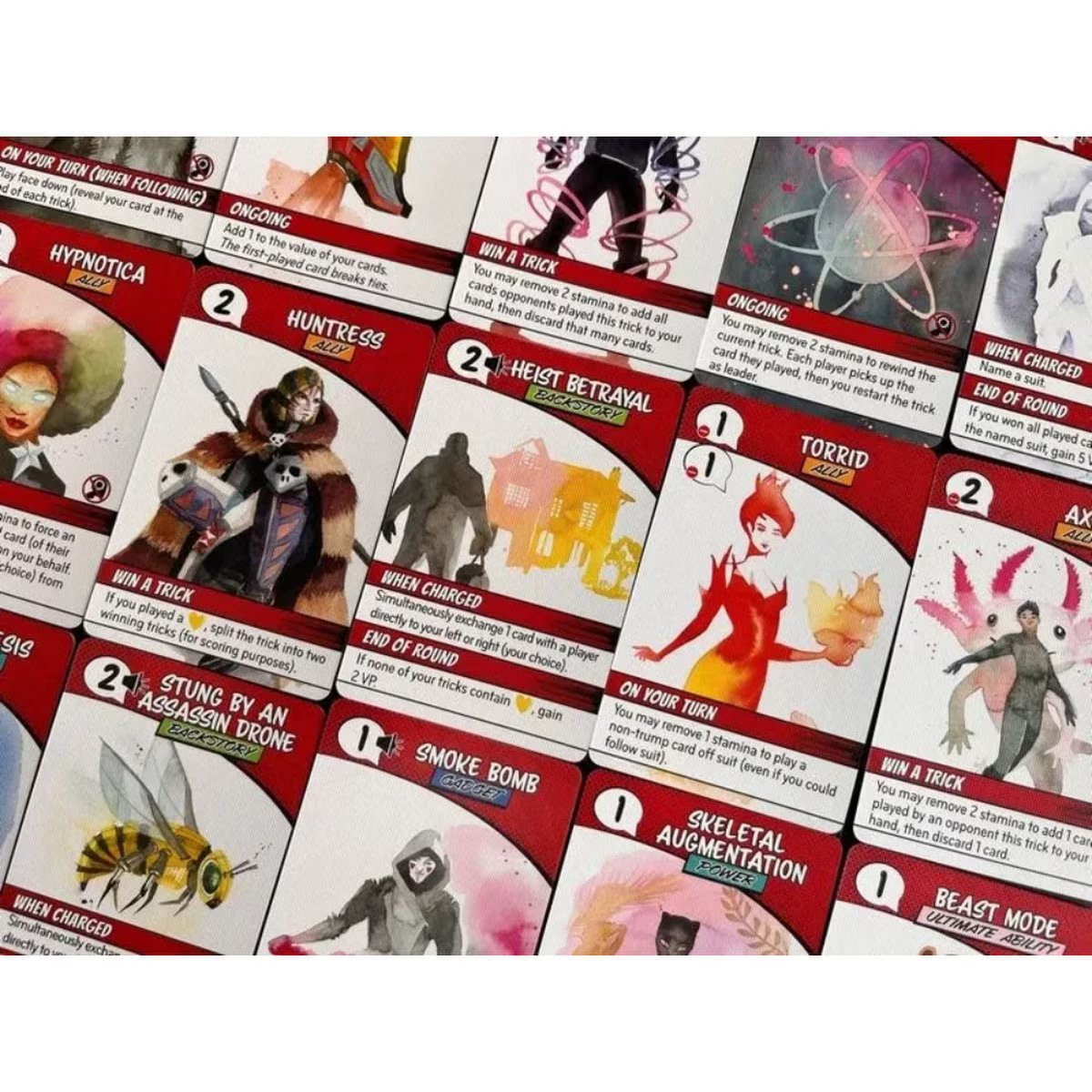 Origin Story card game close-up of red story cards with superhero abilities and trick-taking effects