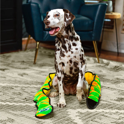 Dalmatian with Outward Hound Durablez Snake Green XXL plush dog toy on an indoor rug
