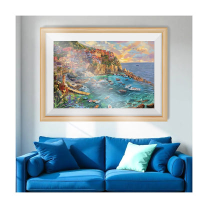 Framed Amalfi Cove jigsaw puzzle artwork displayed as wall art above a sofa in a living room setting
