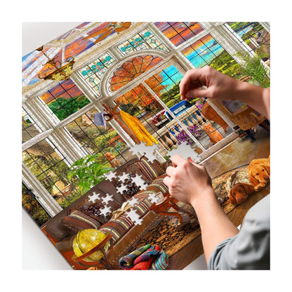 RGS Garden Room 1500pc puzzle in progress showing hand placing pieces in sunroom window scene