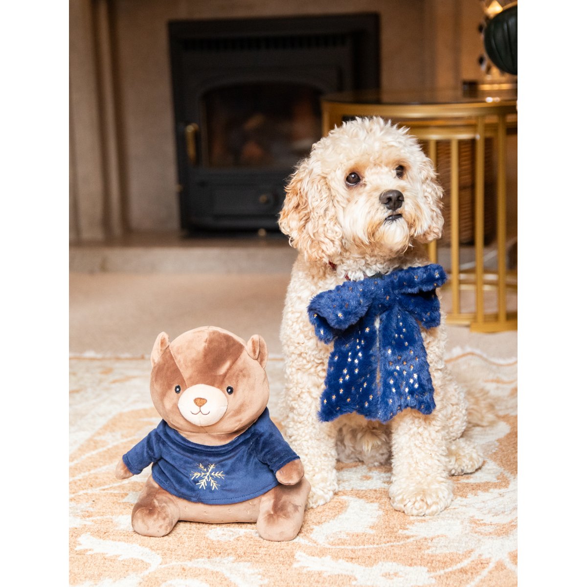 Rosewood Bart Bear brown plush Christmas dog toy displayed beside a cream-coloured dog wearing a festive blue scarf.