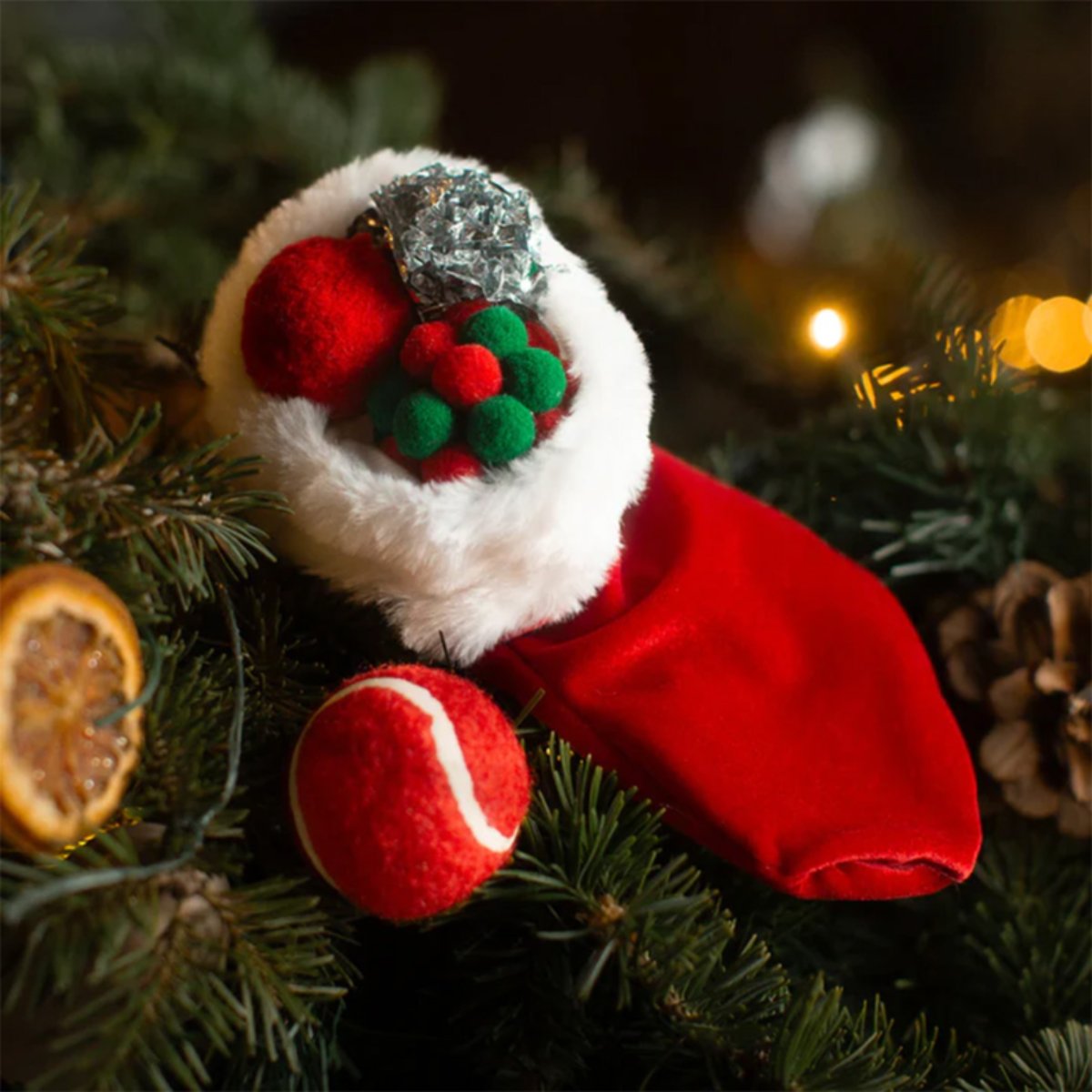 Rosewood Christmas Cat Toy Stocking displayed among Christmas tree branches with red, green and silver cat play balls and warm festive lights.