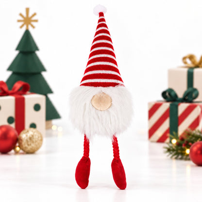 Rosewood Groopert Gonk plush dog toy standing among wrapped Christmas presents with red and white striped hat, fluffy white beard and red rope legs.