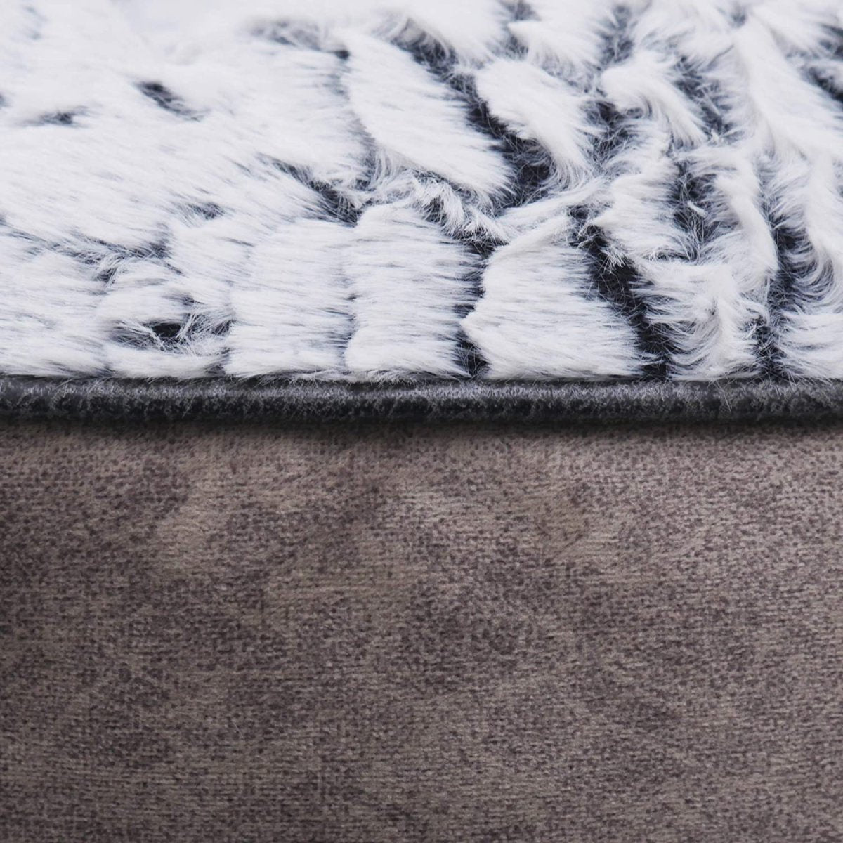 Close-up of the Rosewood Luxury Fleece Lined Plush Dog & Cat Bed showing its fluffy grey and white patterned faux fur lining and smooth grey exterior fabric.