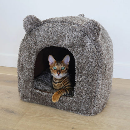 Cat resting inside the brown Rosewood Luxury Teddy Bear Cat Cave Bed in a home setting