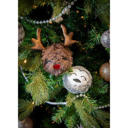 Rosewood Ralphie Reindeer and Parker Penguin fluffy Christmas dog toys nestled among branches of a decorated Christmas tree.