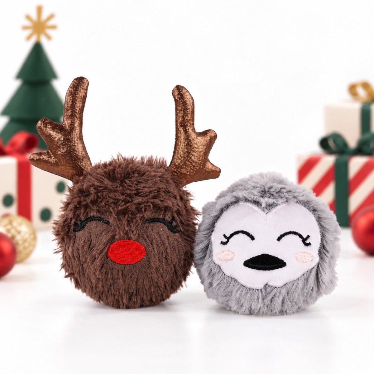 Rosewood Ralphie Reindeer and Parker Penguin Christmas plush dog toys displayed with festive presents and Christmas decorations.