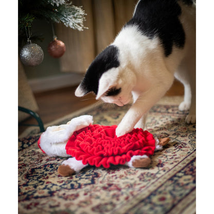 Black and white cat placing its paw into the red fabric folds of the Rosewood Steve Santa Snuffle Mat during an interactive foraging activity.