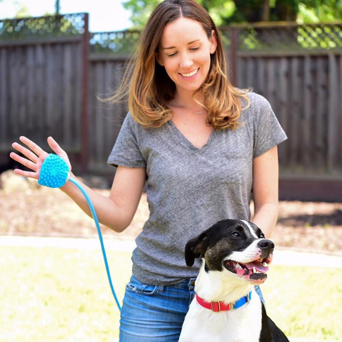 Woman using Rosewood Aquapaw Bathing Tool with dog outdoors