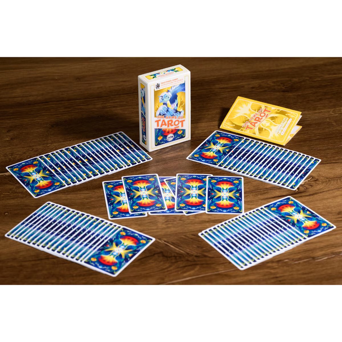 The Game of Tarot card game table setup showing Tarot cards, box and rulebook on a wooden table