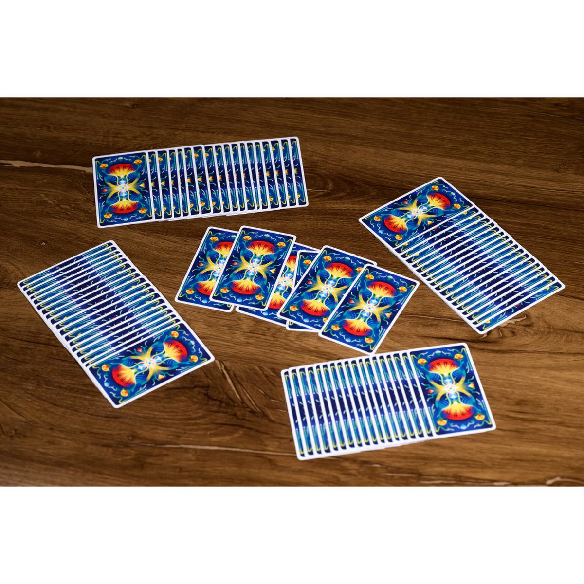 The Game of Tarot trick-taking card layout showing multiple hands of cards and played cards on a table