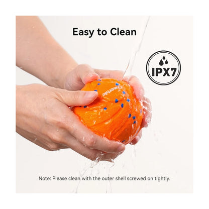 Orange interactive dog ball being rinsed under water with IPX7 waterproof rating icon