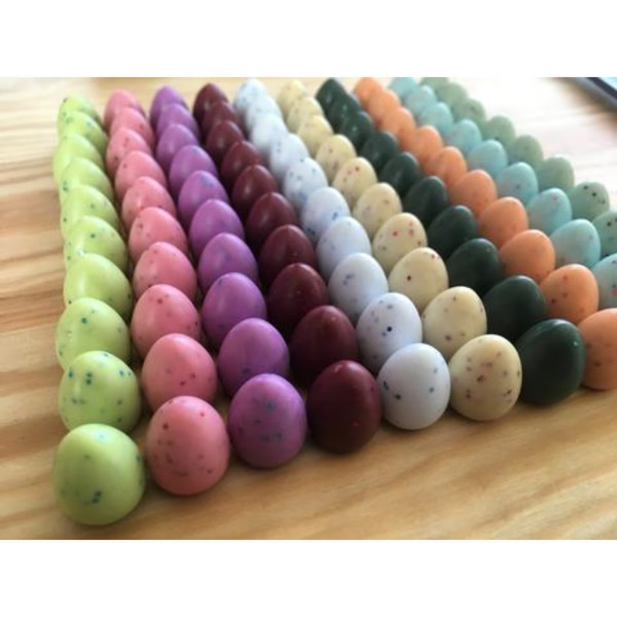 Rows of Wingspan wooden speckled egg tokens in different colours
